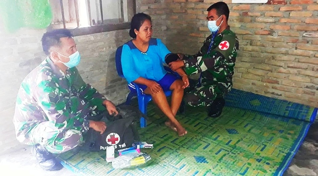 Personil Satgas TMMD melakukan pemeriksaan kesehatan pada warga.