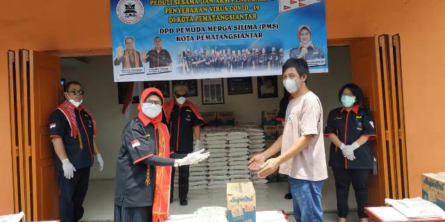 Penyerahan bantuan pangan secara simbolis oleh Penasehat PMS, Susanti Dewayani kepada salah seorang warga.