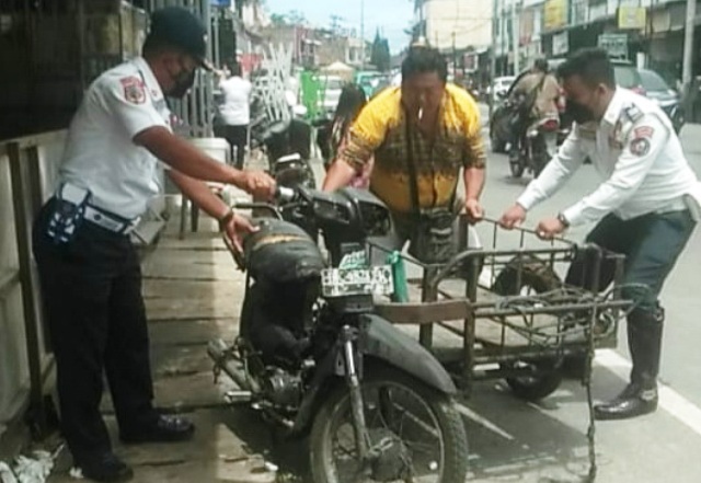 Petugas Dinas Perhubungan Pemkab Taput melakukan penataan kendaraan.