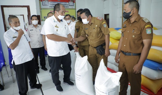 Wakil Bupati Asahan, Taufik Zainal Abidin Siregar menyerahkan bantuan beras untuk disalurkan pada warga korban banjir.