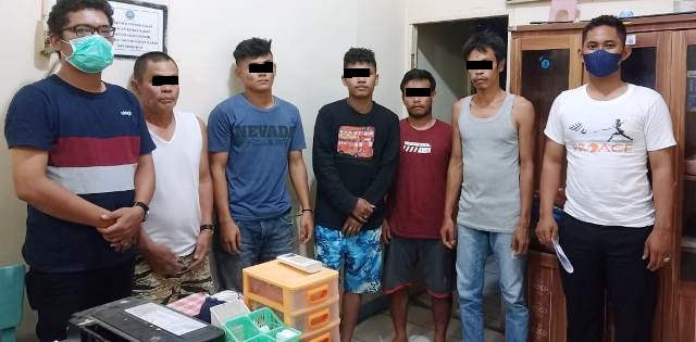 Lima orang yang dinyatakan postif narkoba diapit petugas.